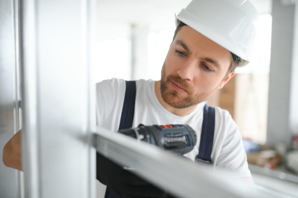 drywall worker works on building site in a house.